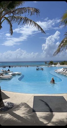 people are swimming in the pool near the beach