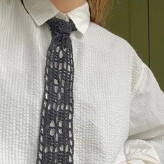 a close up of a person wearing a white shirt and tie with black crochet