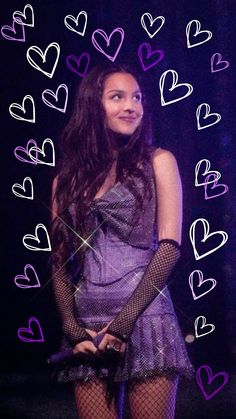 a woman wearing fishnet stockings with hearts drawn on the wall behind her in front of a purple background