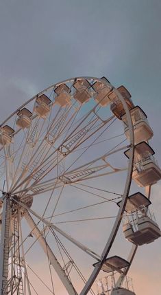 an old ferris wheel in front of a cloudy sky