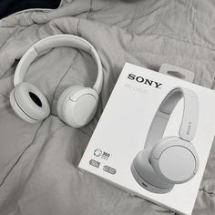 the sony headphones are in its box on top of the bed, next to it's packaging