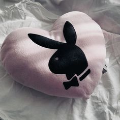 a pink heart shaped pillow with a black rabbit on it