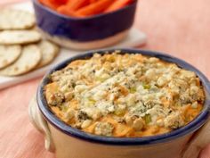 a blue bowl filled with food next to crackers