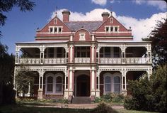 an old house with white balconies and red brick on the front porchs