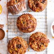 several muffins on a cooling rack next to orange slices and other food items