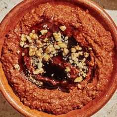 a brown bowl filled with food on top of a table