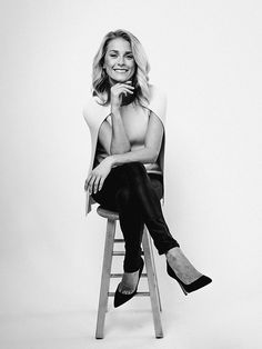 a black and white photo of a woman sitting on a chair