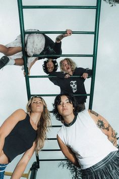 four women are standing on a ladder and posing for the camera