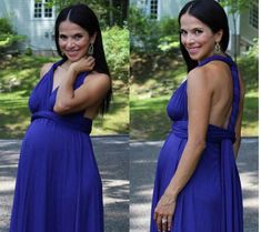 two women in blue dresses standing next to each other on the street with trees behind them