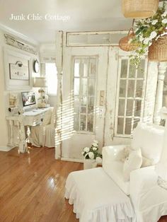 a living room with white furniture and wooden floors