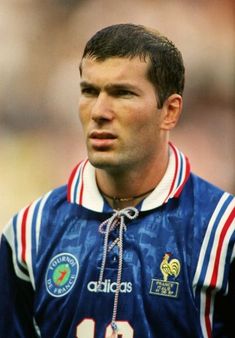 a close up of a soccer player wearing a blue shirt with red and white stripes