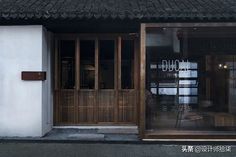 the outside of a restaurant with glass doors and wooden slats on the front door