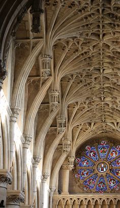 the interior of a large cathedral with an elaborate stained glass window