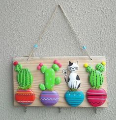 a wooden sign hanging on the side of a wall with cactuses and cacti