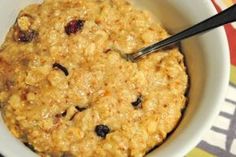 a bowl filled with oatmeal and raisins on top of a table