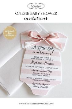 a pink and white striped onesie baby shower card with a bow on the front