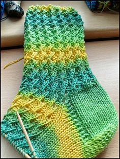 a green and yellow knitted object on top of a table