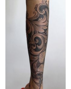 a woman's leg with tattoos on it and her foot in the air,