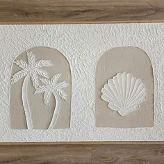 two seashells and a palm tree are on the wall in this art work