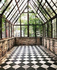 an empty room with lots of windows and black and white checkered tile flooring