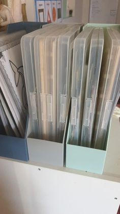 there are many files in the holder on this desk top shelf, all stacked up and ready to be filled with them