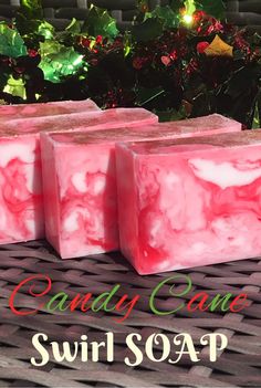 three pink soap bars sitting on top of a wicker table next to christmas decorations