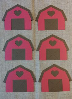 four pieces of paper cut out to look like barns with hearts on the top and bottom