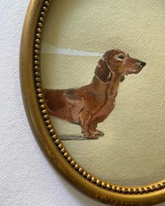 a painting of a dachshund in a gold frame