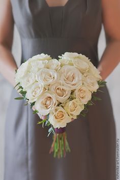 a bride holding a bouquet of white roses