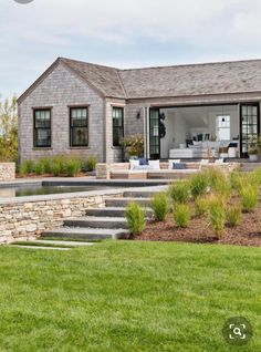 a house that is sitting in the grass with stairs leading up to it's front door