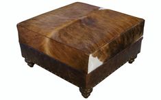 a brown and white cow hide ottoman