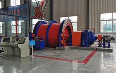 a large red and blue machine inside of a building with other machinery in the background