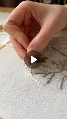 someone is stitching something on a piece of fabric