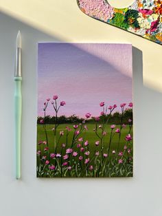 a painting of pink flowers on a canvas next to a paintbrush