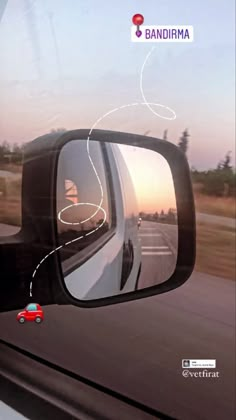 a car's rear view mirror is shown with the sun setting in the background