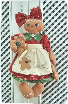 a stuffed teddy bear wearing a dress and holding a cookie