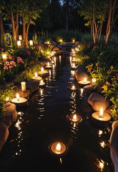 many lit candles are floating in the water near some trees and bushes, along with flowers