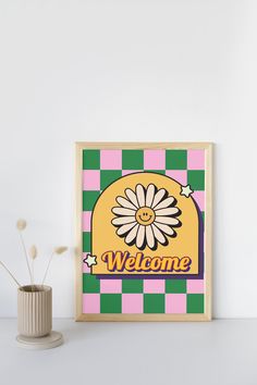 there is a small vase with flowers in it next to a sign that says welcome