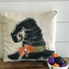 a white pillow with a witch hat on it next to some eggs and a bowl