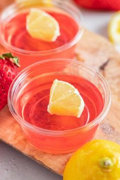 two glasses of strawberry lemonade on a cutting board