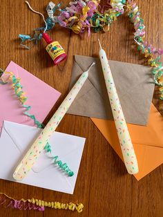 birthday candles and confetti sticks are on the table next to some crafting supplies