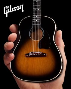 a person holding an acoustic guitar in their hand with the caption gibson logo on it