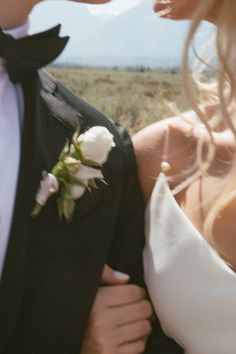 a man in a tuxedo and a woman in a white dress are kissing each other