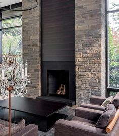 a living room with two couches and a chandelier hanging from the ceiling