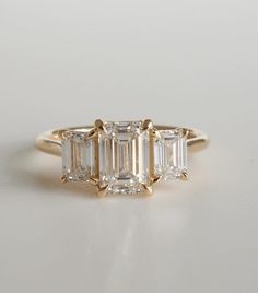 three stone diamond ring in yellow gold with baguets on the sides and side stones