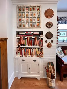 a bookshelf filled with lots of books next to a wall covered in pictures