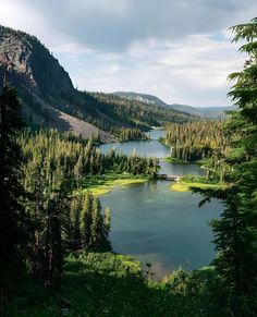 a lake surrounded by trees in the middle of a mountain range with lots of water