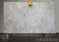 a large white marble slab is being worked on by a person with a yellow tool