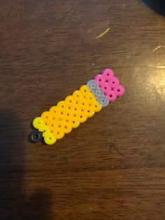 three plastic pegs sitting on top of a wooden table