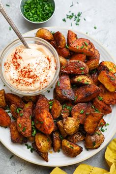 a white plate topped with potatoes and dip